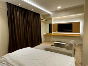 a bedroom with a bed and a flat screen tv at ARMERIA STAY 309 in Lucknow