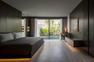 a bedroom with a bed and a desk and a window at INSPIRA Seminyak in Seminyak +42 photos