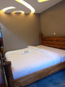 ein Schlafzimmer mit einem großen Bett mit weißer Bettwäsche in der Unterkunft OLENG'OTI GARDENS in Narok