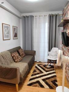 a living room with a couch and a tv at The Arezzo Haven in Davao City