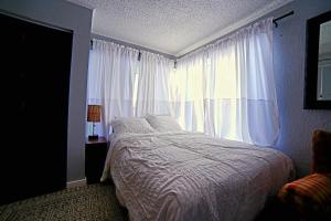 a bedroom with a bed and a large window at SHALIGOHOMES QUEEN SUITE ON 16TH in Anchorage