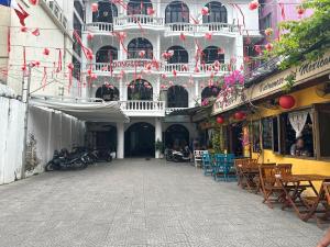 a building with a balcony and tables and chairs at Dong Loi Hotel in Hue