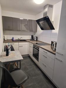 a kitchen with white cabinets and a table with a small table sidx sidx at MY HOME N 35/2 in Villingen-Schwenningen