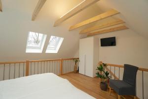 ein Schlafzimmer mit einem Bett und einem Stuhl in der Unterkunft Apartement Dom-Blick in Schleswig