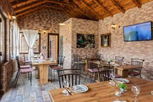 a restaurant with wooden tables and chairs and a tv at Apartments Green Park in Rakovica