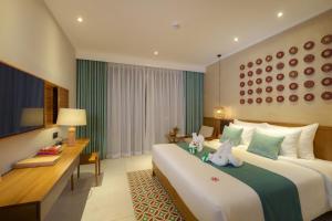 ein Hotelzimmer mit 2 Betten und einem Schreibtisch in der Unterkunft Little Gem. An Eco-Friendly Boutique Hotel & Spa in Hoi An
