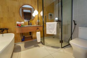 a bathroom with a shower and a toilet and a sink at Little Gem. An Eco-Friendly Boutique Hotel & Spa in Hoi An