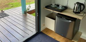 a small refrigerator in a kitchen next to a door at Bungalow Tiny House Puunui 