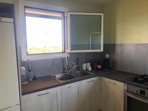 cocina con fregadero y ventana en Beautiful Farm House, en Filiatra