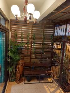 a wooden bench sitting in a room with plants at Classic Home Stay Hatyai in Ban Tha Sae