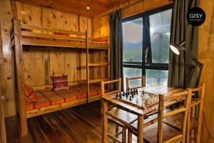 Sóc SơnにあるGISY Lake Houseのデスク、二段ベッド、テーブルが備わる客室です。
