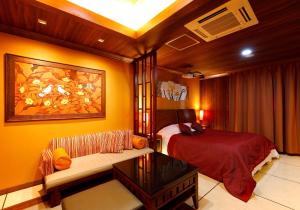 - une chambre avec un lit et un canapé dans l'établissement ホテルウォーターゲート香芝, à Kashiba