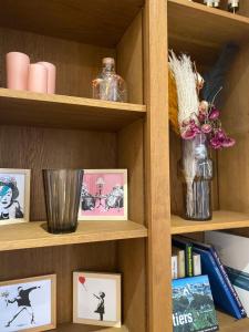 ein Bücherregal mit Bildern und eine Vase mit Blumen in der Unterkunft Comedy: heart of town facing the NA region in Poitiers