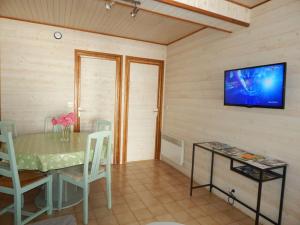 a dining room with a table and a television on a wall at Maison avec jardin proche gare plage intramuros chien admis Fibre in Saint Malo