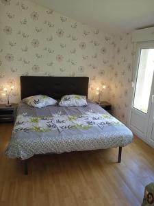 un letto con due cuscini sopra in una camera da letto di Maison avec jardin proche gare plage intramuros chien admis Fibre a Saint Malo