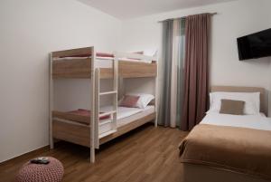 a small room with two bunk beds and a television at Villa Oliva - Adriatic Luxury Villas in Murvica +23 photos