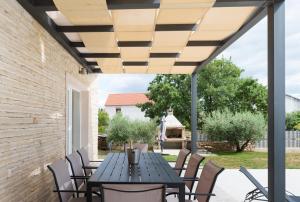 a patio with a black table and chairs at Villa Oliva - Adriatic Luxury Villas in Murvica
