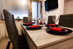 - une table avec des verres à vin et des serviettes rouges dans l'établissement Transylvanian Hideaway Apartment, à Sibiu