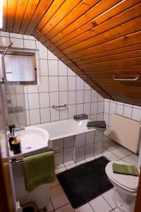 une salle de bain avec une baignoire blanche et des toilettes dans l'établissement Transylvanian Hideaway Apartment, à Sibiu