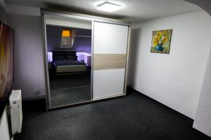 Cette chambre dispose d'une porte avec un miroir et d'un lit. dans l'établissement Transylvanian Hideaway Apartment, à Sibiu