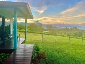 un porche de una casa con vistas a un campo en Bungalow Tiny House Puunui, 