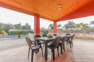 un patio con mesa de comedor y sillas y piscina en 016 - Finca La Dama Valverde - comfortHOLIDAYS en Valverde Alto