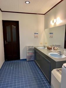 łazienka z 2 umywalkami i brązowymi drzwiami w obiekcie 百合ヶ浜ビーチハウス w mieście Furusato