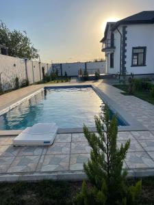 巴庫的住宿－Villa near SeaBreeze Nardaran Baku，一座房子旁的游泳池,带躺椅