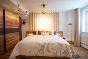a bedroom with a large bed and a chandelier at Residence Moritz in Mozirje