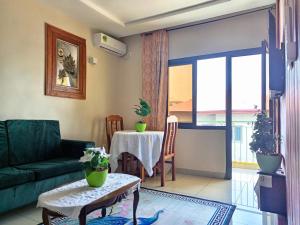 a living room with a green couch and a table at RÉSIDENCE DES 7 COLLINES in Yaoundé