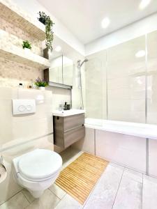 a bathroom with a toilet and a sink and a tub at Spacious ultracentral modern apartment in Târgu-Mureş