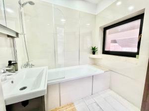 a white bathroom with a sink and a mirror at Spacious ultracentral modern apartment in Târgu-Mureş
