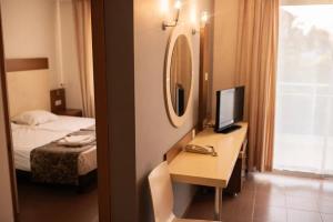 a hotel room with a desk with a television and a bed at Akalia Suite Hotel & SPA in Side