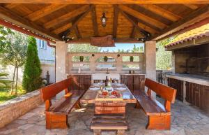 een patio met een tafel en 2 banken bij Family House SEA MARE I in Pula