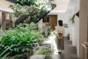 uma mulher andando por um corredor com plantas em Norden Ruder Hostel Taitung em Taitung City