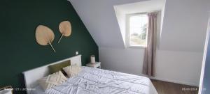 a bedroom with a bed with a green wall at Location LOC'MARIA - Résidence Marie-Galante - Location Professionnelle in Locmaria