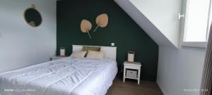 1 dormitorio con cama y pared verde en Location LOC'MARIA - Résidence Marie-Galante - Location Professionnelle en Locmaria
