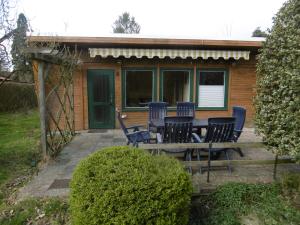 a patio with a table and chairs in front of a house at Ferienbungalow Am Birkenwäldchen in Kolonie Röntgental