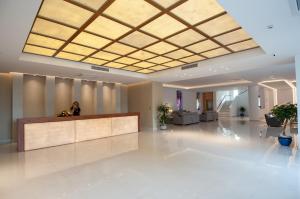 a lobby with a person sitting at a counter in a building at Mediterranean Beach Resort in Laganas