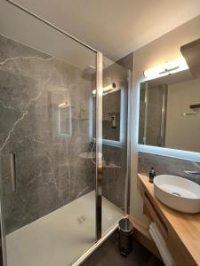 La salle de bains est pourvue d'une douche et d'un lavabo. dans l'établissement Logis - Hôtel de la Baie de Somme, au Crotoy