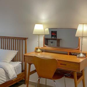 a bedroom with a desk with two lamps and a bed at Modeul Stay in Seoul