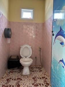 ein Bad mit einem WC und einem an der Wand gemalten Delphin in der Unterkunft Baan chidlomlay in Don Sak
