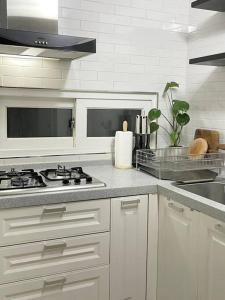 a kitchen with white cabinets and a stove top oven at Modeul Stay in Seoul
