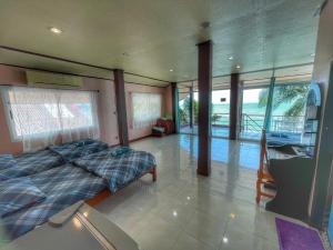 ein Schlafzimmer mit einem Bett in einem Zimmer mit Fenstern in der Unterkunft Baan chidlomlay in Don Sak