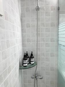 three black bottles sitting on a shelf in a shower at Modeul Stay in Seoul