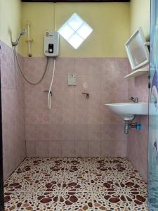 ein Bad mit einem Waschbecken und einer Dusche mit einem Waschbecken in der Unterkunft Baan chidlomlay in Don Sak