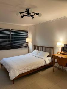 a bedroom with a bed and a desk and a ceiling fan at Modeul Stay in Seoul