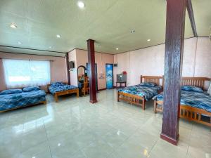 Zimmer mit 3 Betten und einem Spiegel in der Unterkunft Baan chidlomlay in Don Sak