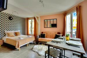 a bedroom with a bed and a table and a couch at 145 Suite Marco - Superbe Appartement à Paris in Paris