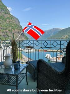 uma bandeira britânica numa varanda com uma mesa e cadeiras em Svingen Guesthouse - Panoramic Fjord Views in Flåm em Flåm